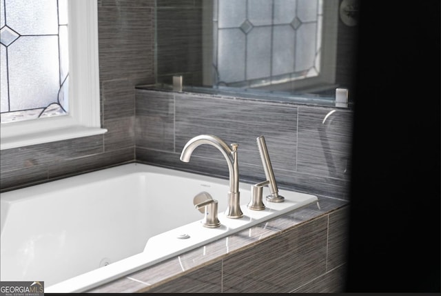 bathroom with a relaxing tiled tub and sink