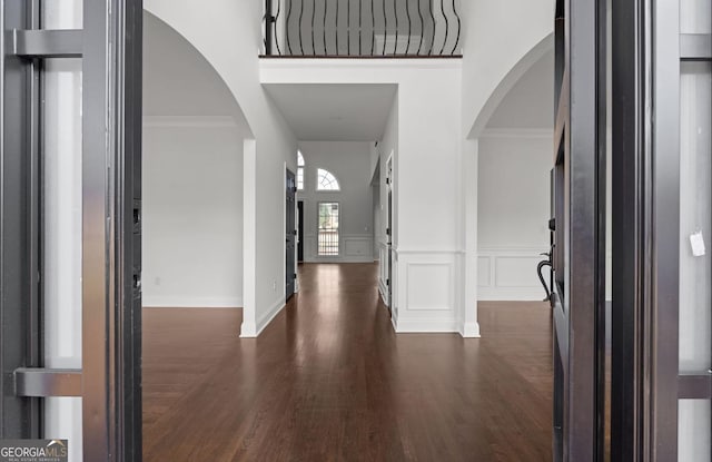 foyer entrance featuring ornamental molding and dark wood-type flooring