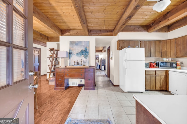 kitchen featuring beam ceiling, light tile patterned floors, white appliances, and wooden ceiling