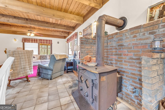 tiled living room with beam ceiling, wooden ceiling, ceiling fan, and a wood stove