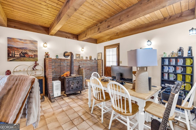 dining area with beam ceiling, light tile patterned floors, wood ceiling, and a wood stove