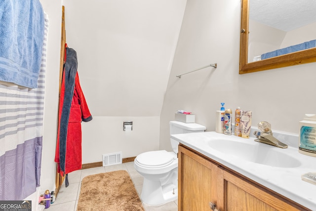 bathroom featuring tile patterned flooring, vanity, a textured ceiling, vaulted ceiling, and toilet