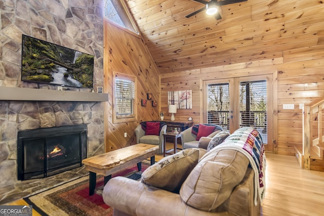 living room with wooden walls, wooden ceiling, and a fireplace