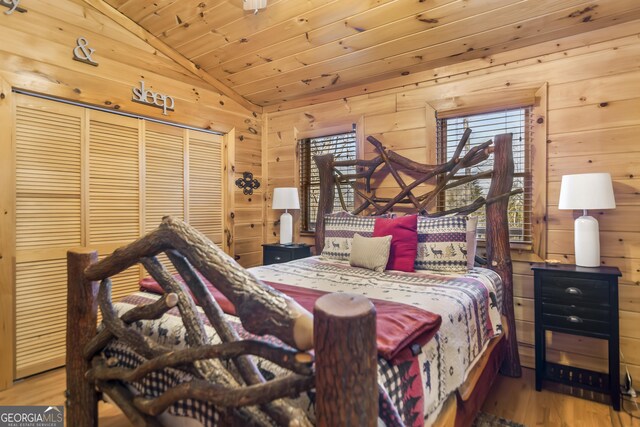 bedroom with lofted ceiling, wood ceiling, and wood walls