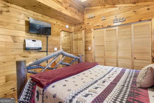 bedroom featuring lofted ceiling, wooden walls, wood ceiling, and a closet