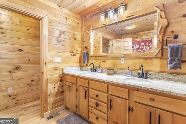 bathroom featuring wooden ceiling, vanity, and wood walls