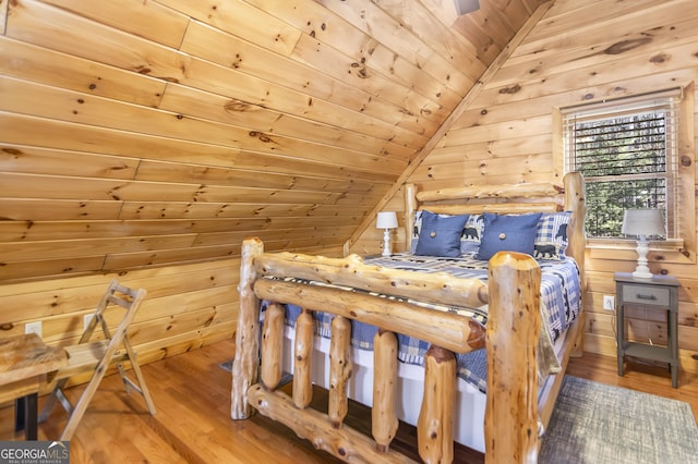 bedroom with wood ceiling, lofted ceiling, wooden walls, and hardwood / wood-style floors