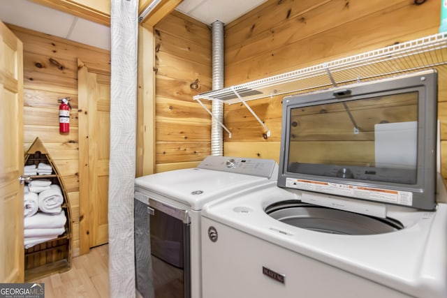 211 Highland Forest Dr, Morganton, GA 30560 - laundry area with light wood-type flooring, wood walls, and washing machine and clothes dryer