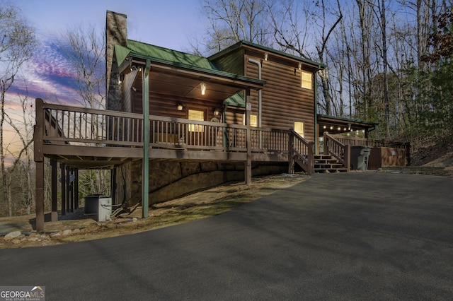 211 Highland Forest Dr, Morganton, GA 30560 - view of front facade featuring a deck, log veneer siding, metal roof, and a chimney