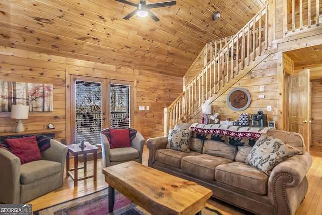 living room with lofted ceiling, wooden walls, wooden ceiling, and light wood-type flooring