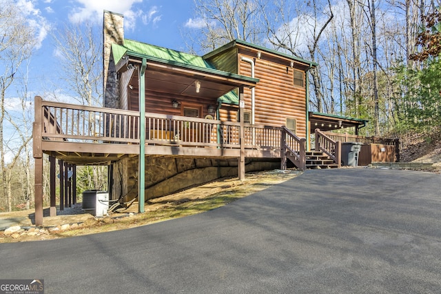 211 Highland Forest Dr, Morganton, GA 30560 - view of front facade with a chimney, log veneer siding, a deck, and metal roof