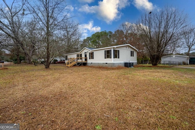 view of front of house featuring cooling unit and a front lawn