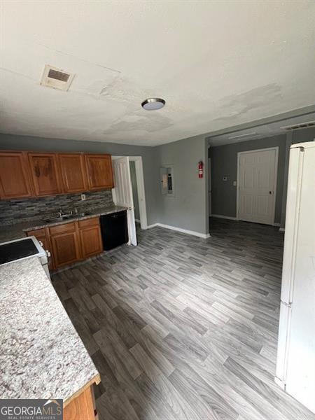 4402 Highland Rd, Decatur, GA 30035 - kitchen with range, wood finished floors, brown cabinetry, backsplash, and light countertops