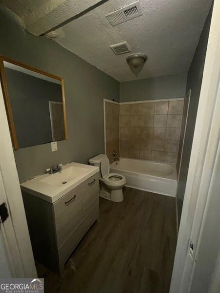 4402 Highland Rd, Decatur, GA 30035 - full bath featuring vanity, wood finished floors, bathtub / shower combination, and a textured ceiling