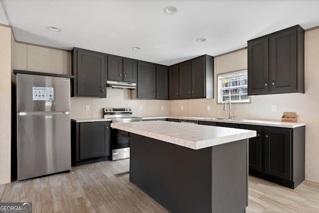 kitchen featuring stainless steel appliances, a center island, sink, and light hardwood / wood-style floors