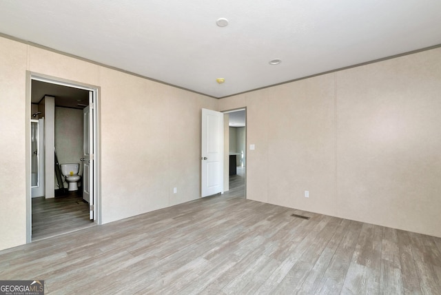 unfurnished room with crown molding and light wood-type flooring