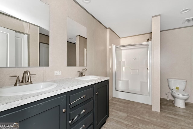 bathroom featuring hardwood / wood-style floors, ornamental molding, toilet, and walk in shower