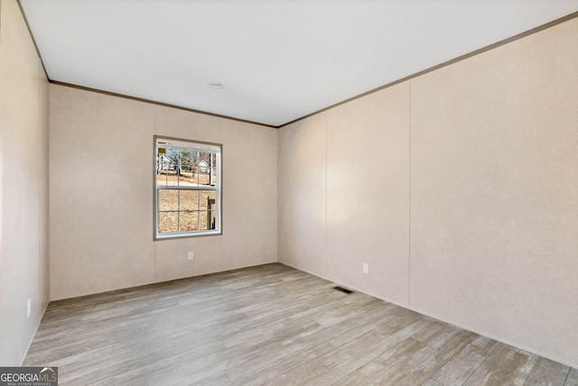 unfurnished room featuring crown molding and light hardwood / wood-style floors