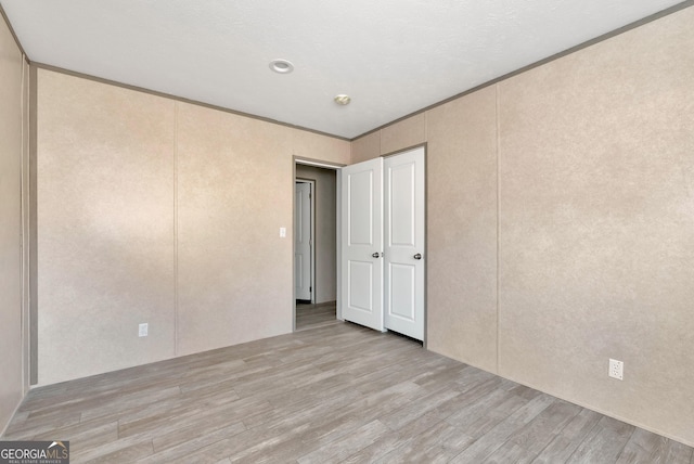 spare room featuring ornamental molding and light hardwood / wood-style floors