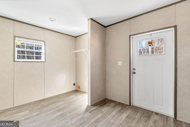 foyer featuring crown molding and light hardwood / wood-style floors