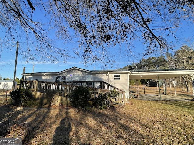 back of property featuring a carport and a deck