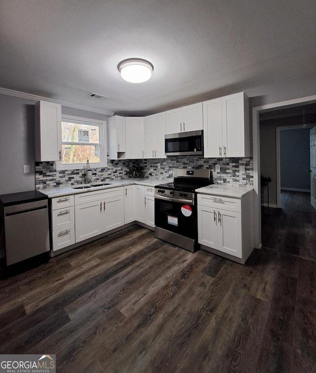1290 Elizabeth Ave SW, Atlanta, GA 30310 - kitchen with appliances with stainless steel finishes, a sink, tasteful backsplash, white cabinets, and light countertops