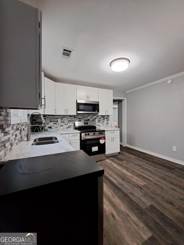 1290 Elizabeth Ave SW, Atlanta, GA 30310 - kitchen featuring stainless steel appliances, a sink, tasteful backsplash, white cabinetry, and baseboards