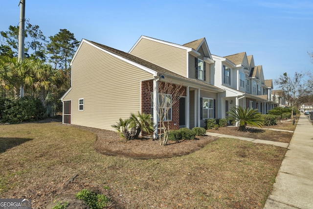 view of property exterior with brick siding, a lawn, and a residential view