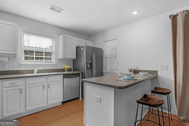 172 Sonata Cir, Pooler, GA 31322 - kitchen featuring stainless steel appliances, light wood finished floors, dark countertops, a breakfast bar, and recessed lighting