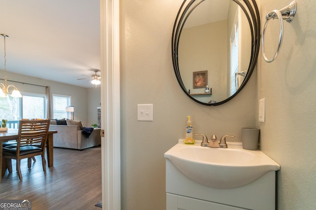 bathroom featuring vanity, ceiling fan with notable chandelier, and hardwood / wood-style floors