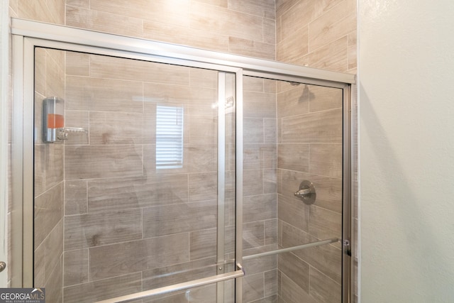 bathroom with a shower with door