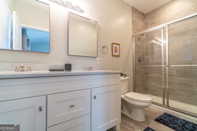 bathroom featuring vanity, an enclosed shower, and toilet