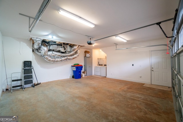 garage with independent washer and dryer and a garage door opener