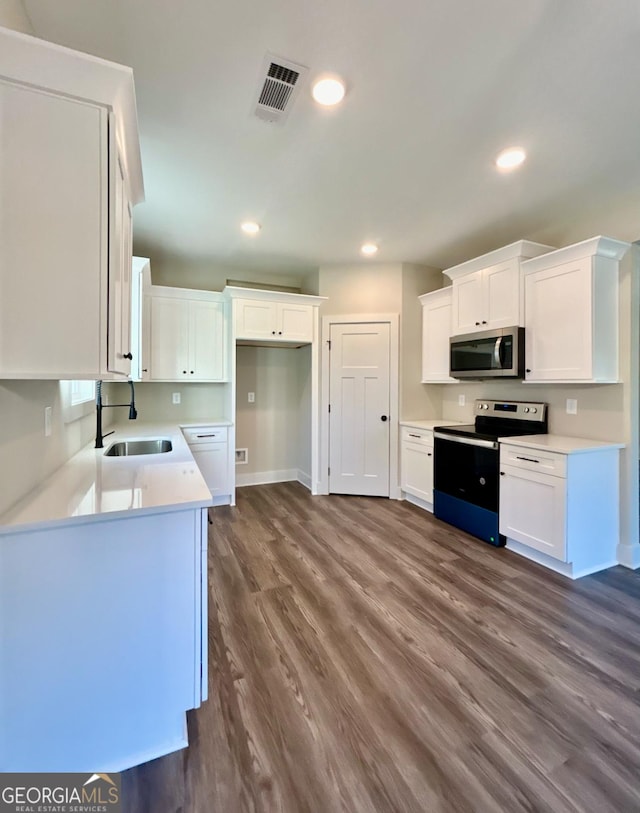 kitchen featuring white cabinetry, sink, stainless steel appliances, and dark hardwood / wood-style floors