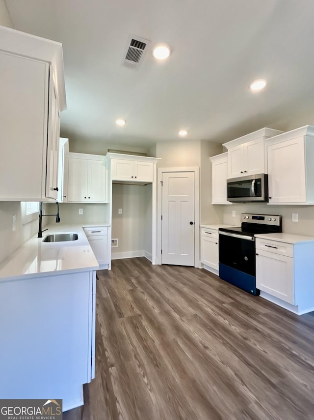 kitchen featuring range with electric cooktop, dark wood-type flooring, sink, and white cabinets