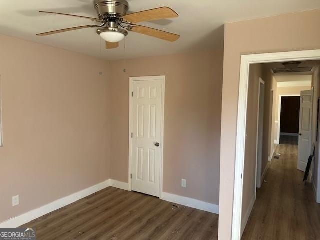 spare room with dark hardwood / wood-style flooring and ceiling fan