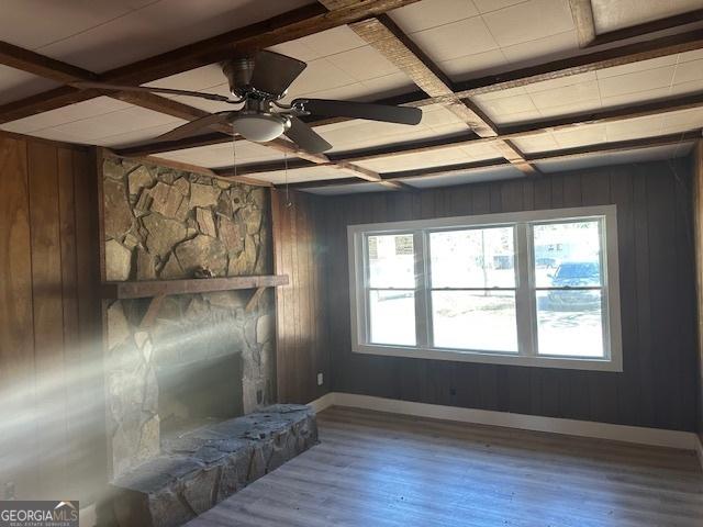 living room with coffered ceiling, a fireplace, wood-type flooring, and wood walls