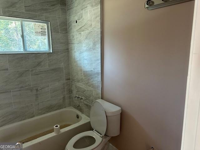 bathroom featuring toilet and tiled shower / bath combo