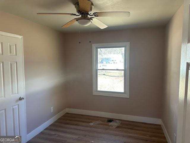 empty room with dark hardwood / wood-style floors and ceiling fan