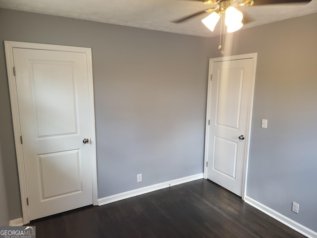 unfurnished room with dark hardwood / wood-style floors and ceiling fan