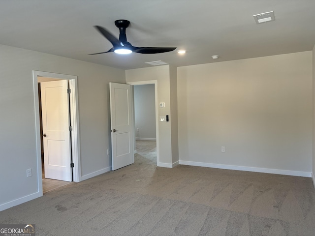 carpeted spare room with ceiling fan