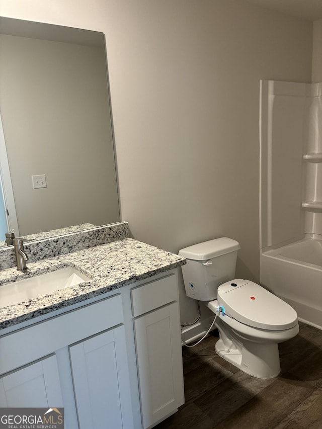 full bathroom with wood-type flooring, vanity, shower / bathtub combination, and toilet