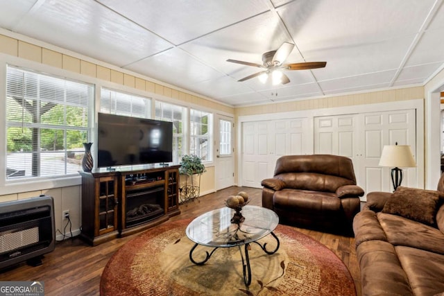 living room with dark wood-type flooring, heating unit, and ceiling fan