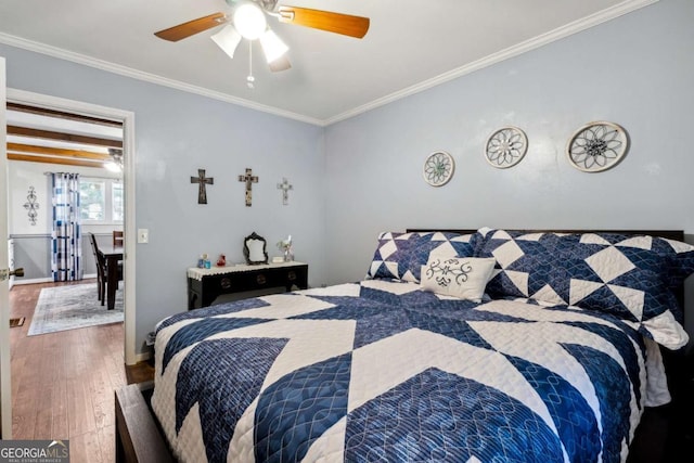 bedroom featuring crown molding, wood-type flooring, and ceiling fan