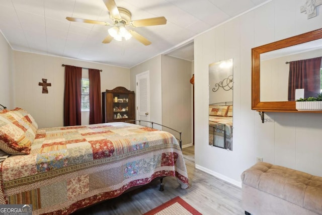 bedroom with crown molding, ceiling fan, and light hardwood / wood-style floors