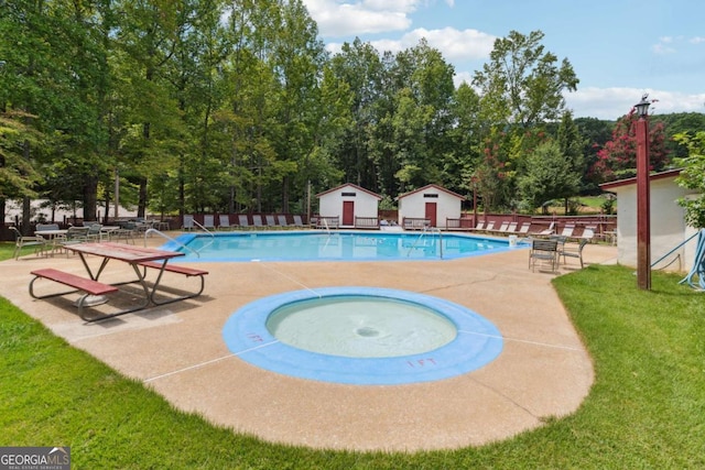 view of pool featuring a yard, a hot tub, and a patio