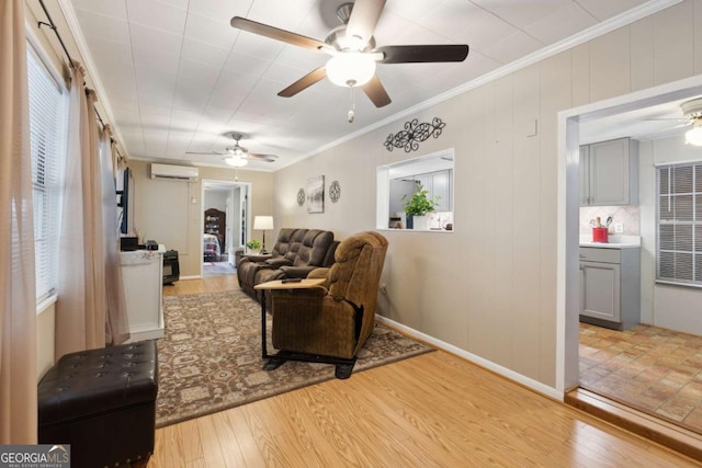 living room featuring crown molding, ceiling fan, light hardwood / wood-style flooring, and an AC wall unit