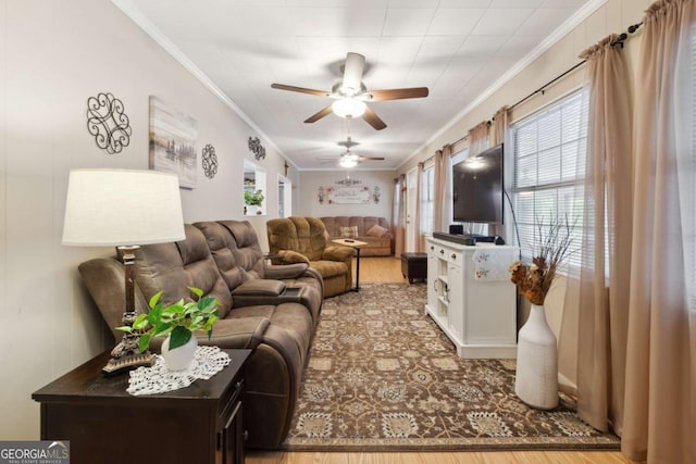 living room with ornamental molding, wood-type flooring, and ceiling fan