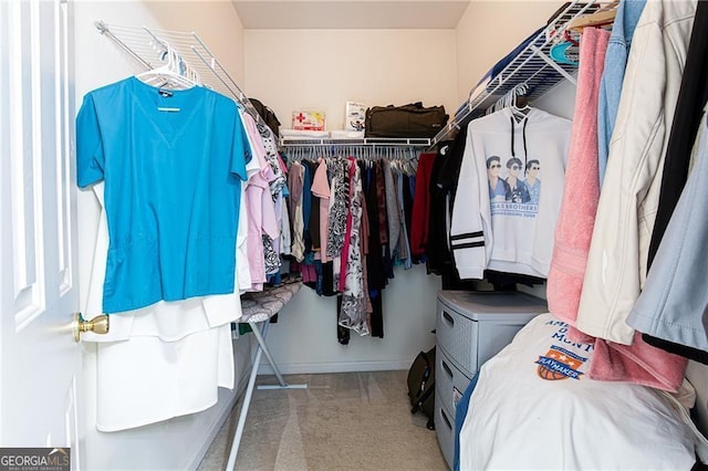 walk in closet with light colored carpet