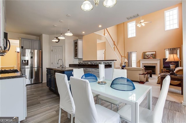 dining space with wood-type flooring, sink, and ceiling fan